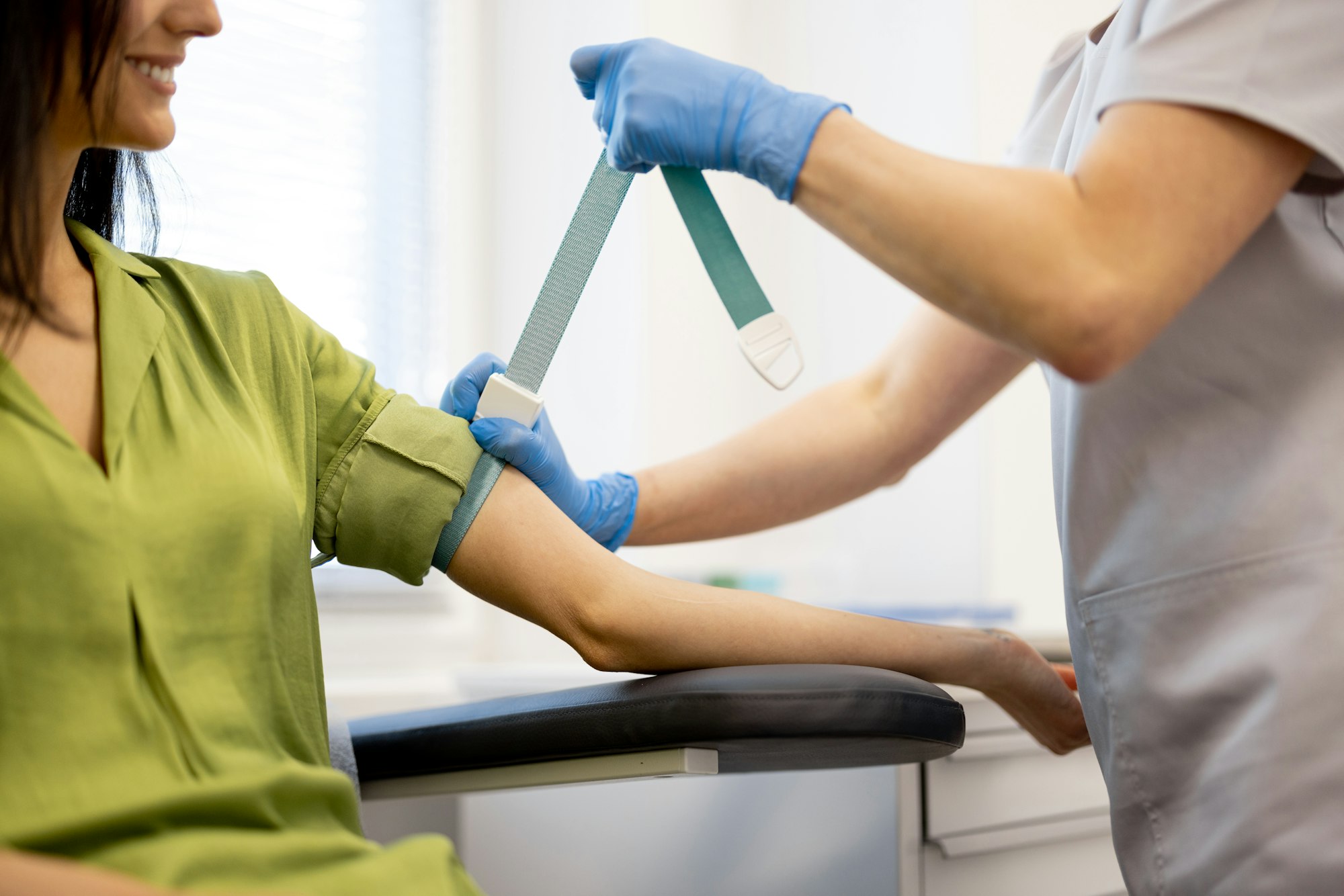 Nurse takes blood test of a young woman in laboratory